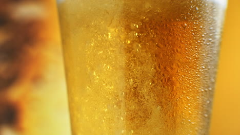 Beer-is-pouring-into-angled-glass.-IPA-on-tap.-Cold-Light-Beer-in-a-glass-with-water-drops.-Craft-Beer-forming-waves-close-up.-Freshness-and-froth.-Bar-background.-Microbrewery-craft-beer.